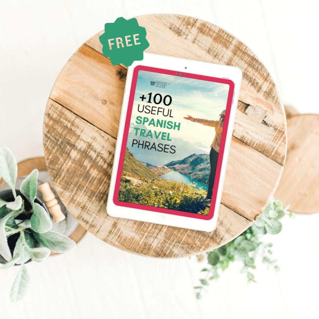 Tablet blanca apoyada sobre taburete de madera con imagen del eBook gratuito para aprender español en la pantalla.